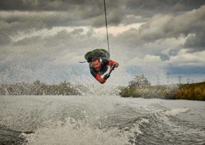 Commercial sports photoshoot by Mark Wildsmith for www.wildsmith.photography. Ian Wilkinson is a GB Kneeboarder. The knee boarder is captured on the river Trent in Nottinghamshire. The athlete is performing a layout which is captured at the top of the move, huge amounts of spray is in the air as the athlete leaps over the wake of the boat.