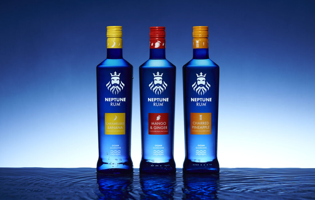 3 bottles of rum made by Neptune rum in Sheffield. vivid blue bottles sat on top of rippling water. Photographed by Mark from Wildsmith Photography. Commercial food photographer and drink photographer based in London and Sheffield.Photographed by Mark Wildsmith from Wildsmith Photography in Sheffield